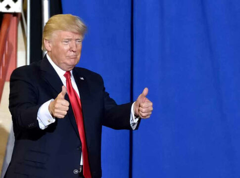 Man in suit giving two thumbs up.