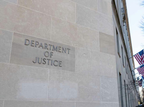 Department of Justice building with American flags outside.