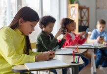 Students using smartphones at classroom desks