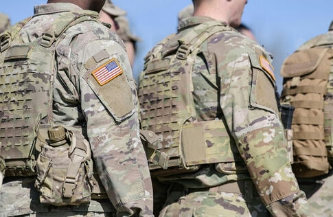 Soldiers in camouflage uniforms with American flag patches.