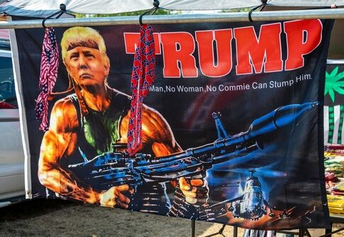 A banner featuring a muscular figure resembling Trump holding a weapon