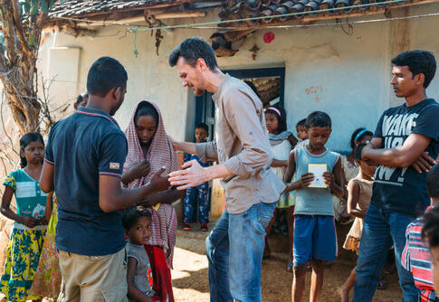 A group of people interacting outdoors in a village.